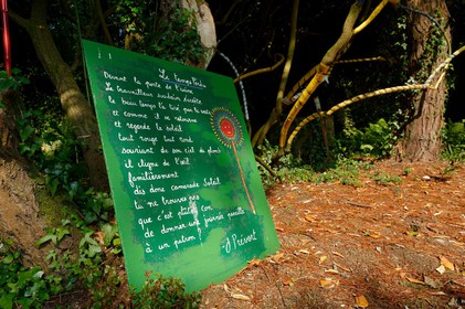 En hommage au poète, ses amis dont Gérard Fusberti, propriétaire du terrain et gardien du temple, décident de créer un jardin où chacun plantera son arbre ou laissera une de ses créations. Montand, Reggiani, Greco ou Mouloudji plantèrent chacun leur double végétal lors de la célébration du dixième anniversaire de la mort de Prévert, un eucalyptus aujourd'hui haut d'au moins 20 mètres pour Mouloudji.Se balader dans ce jardin, c'est pénétrer dans l'univers du poète. Au milieu des arbres d'ornement, des bambous peints de rouge vif, des arbres fruitiers, des camélias, des azalées, des gunneras (que Prévert adorait) et des hortensias, des œuvres d'art se révèlent ça et là, tantôt un portrait, tantôt une sculpture ou une installation. Des arbres peints prennent vie, une main rouge semblant sortir de leur entrailles, le ruisseau qui coule en cascade murmure une douce poésie, que l'on retrouve en quelques phrases inscrites sur des plaques qui surgissent au milieu de cette jungle organisée. (Saint-Germain-des-Vaux Manche)