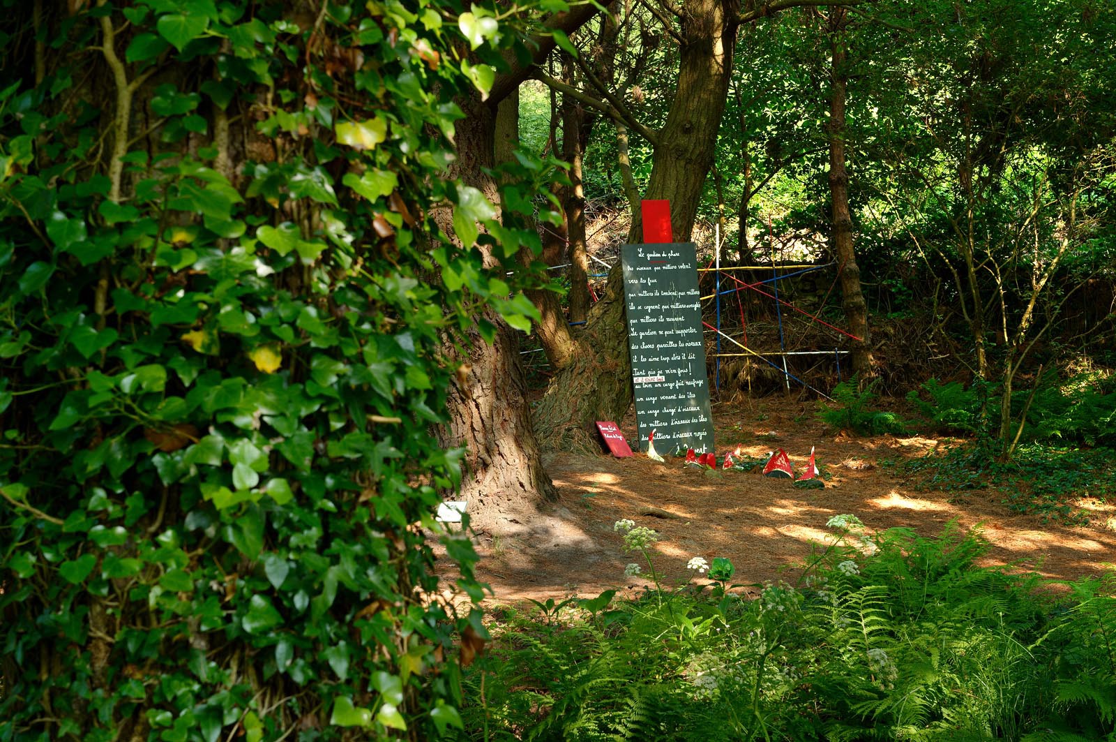 En hommage au poète, ses amis dont Gérard Fusberti, propriétaire du terrain et gardien du temple, décident de créer un jardin où chacun plantera son arbre ou laissera une de ses créations. Montand, Reggiani, Greco ou Mouloudji plantèrent chacun leur double végétal lors de la célébration du dixième anniversaire de la mort de Prévert, un eucalyptus aujourd'hui haut d'au moins 20 mètres pour Mouloudji.Se balader dans ce jardin, c'est pénétrer dans l'univers du poète. Au milieu des arbres d'ornement, des bambous peints de rouge vif, des arbres fruitiers, des camélias, des azalées, des gunneras (que Prévert adorait) et des hortensias, des œuvres d'art se révèlent ça et là, tantôt un portrait, tantôt une sculpture ou une installation. Des arbres peints prennent vie, une main rouge semblant sortir de leur entrailles, le ruisseau qui coule en cascade murmure une douce poésie, que l'on retrouve en quelques phrases inscrites sur des plaques qui surgissent au milieu de cette jungle organisée. (Saint-Germain-des-Vaux Manche)